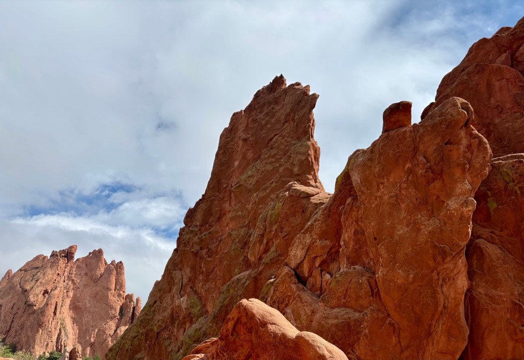 Towering red rock formations under a cloudy sky.