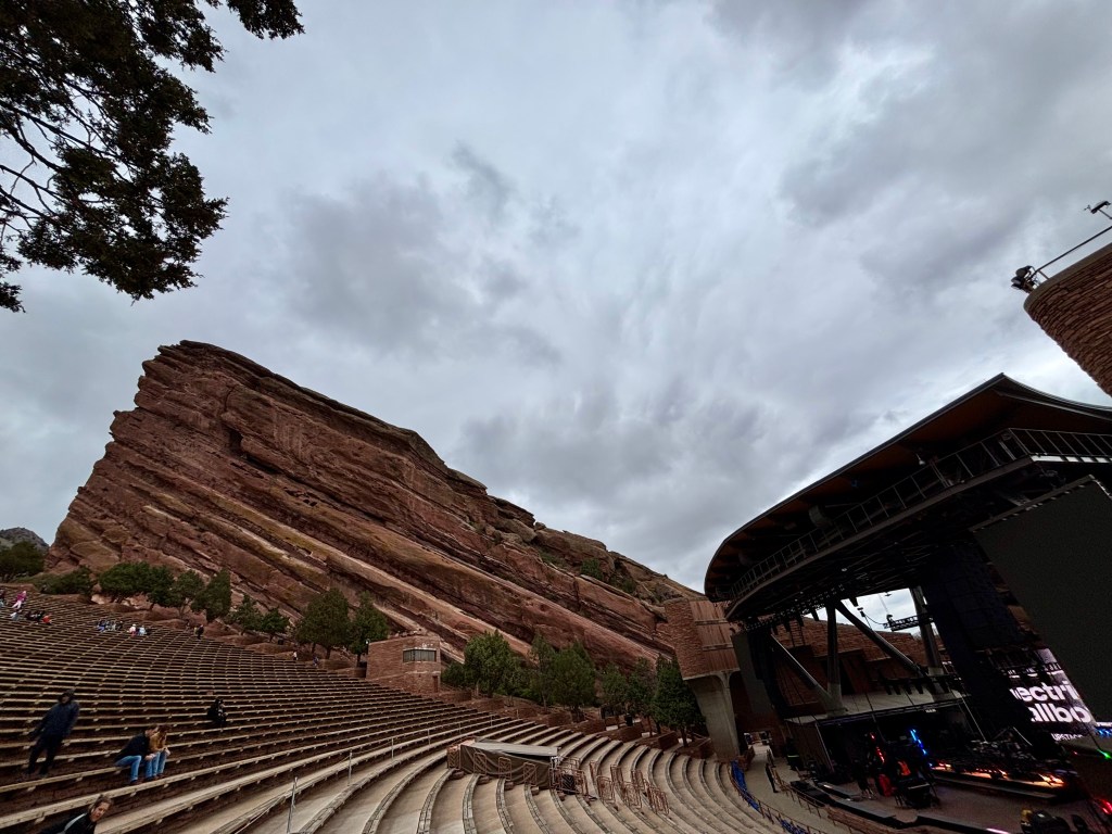 View of Red Rocks Amphitheatre showcasing the seating area, rocky formations, and cloudy sky.